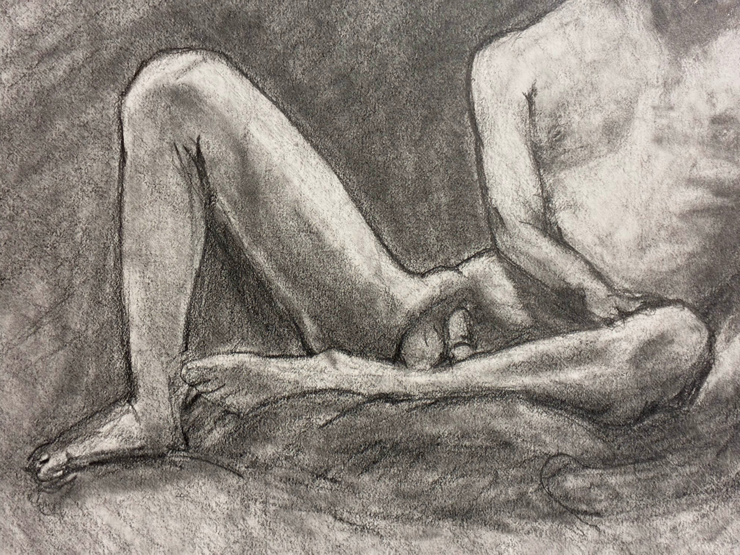 Pencil drawing of a nude figure sitting on the ground.