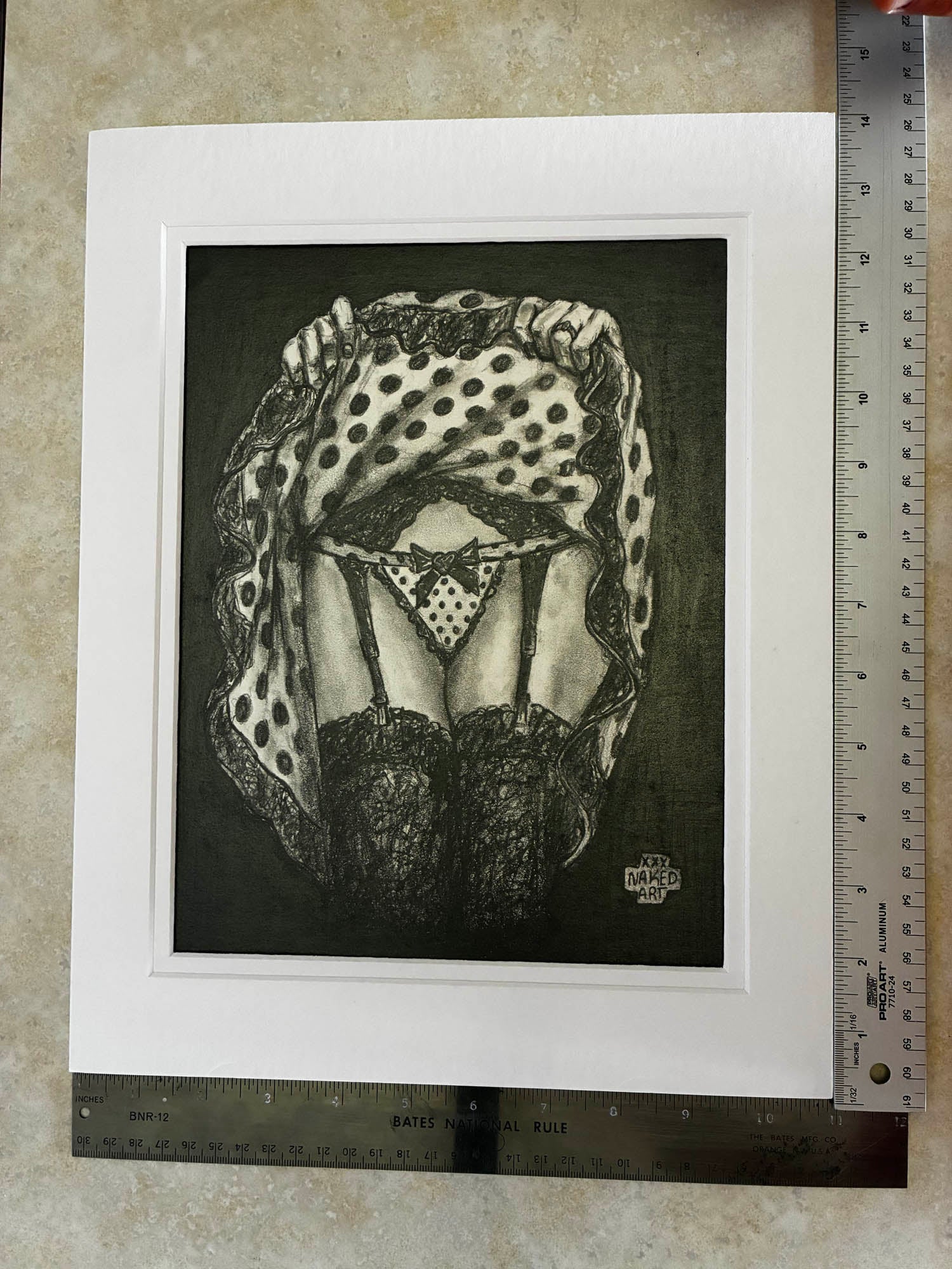 Black and white drawing of a person wearing a patterned headscarf on a textured surface with a ruler for scale.
